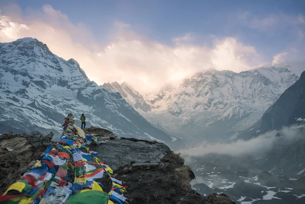 traveler looking at cloudy sunset on annapurna base camp trek